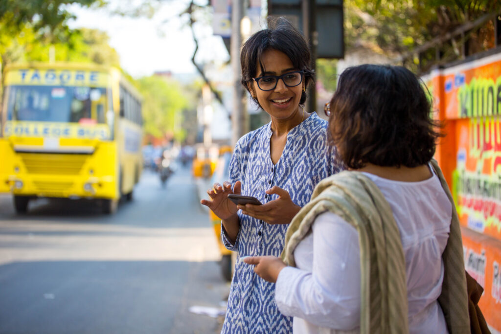 Two employees of CreditMantri talk outdoors