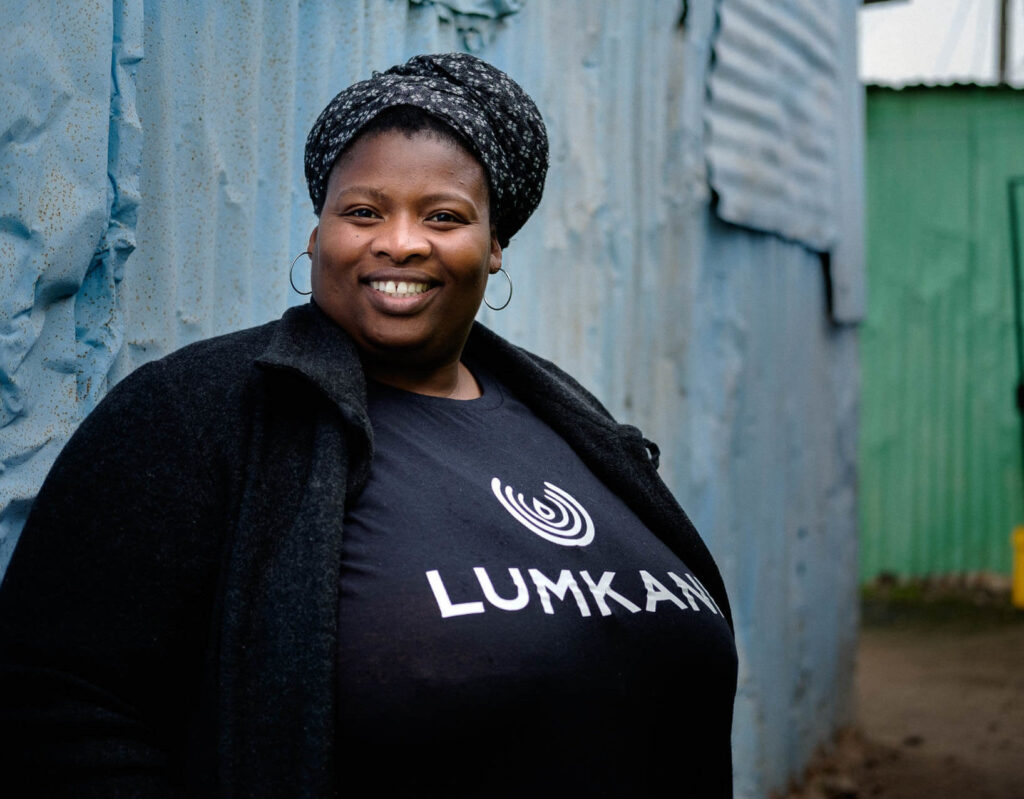 Zoliswa, an agent for Lumkani, in front of an informal settlement in South Africa