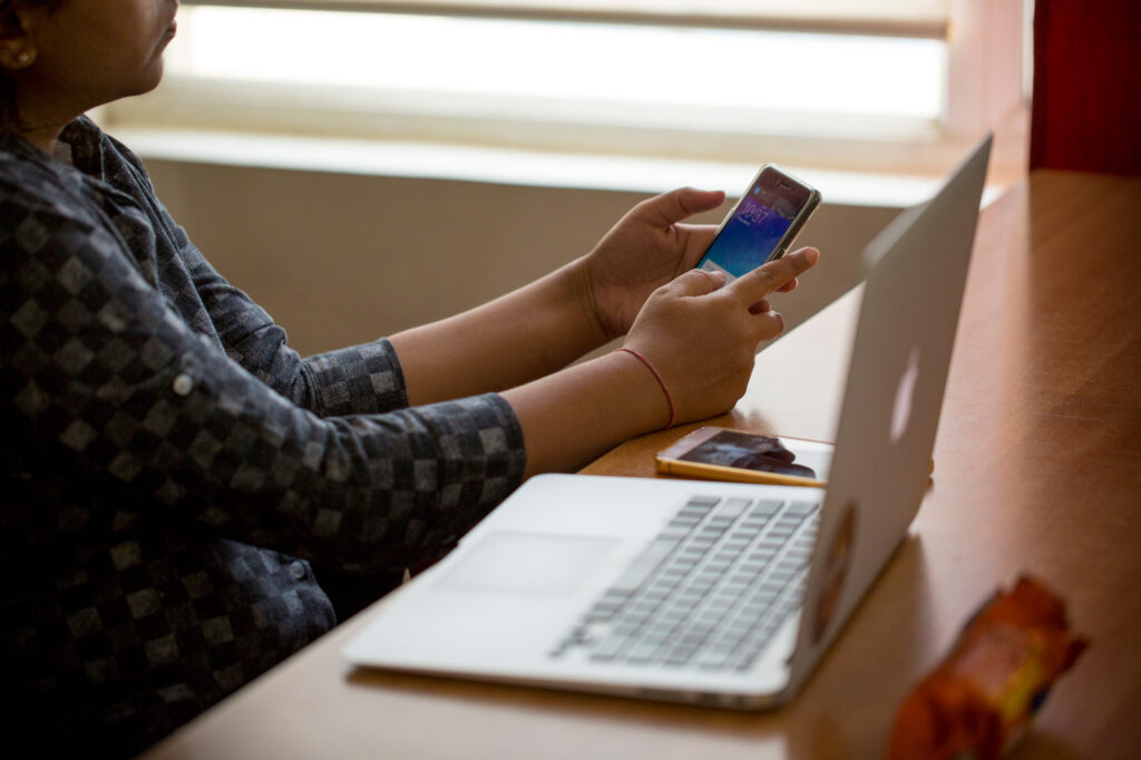 Person using smartphone and computer