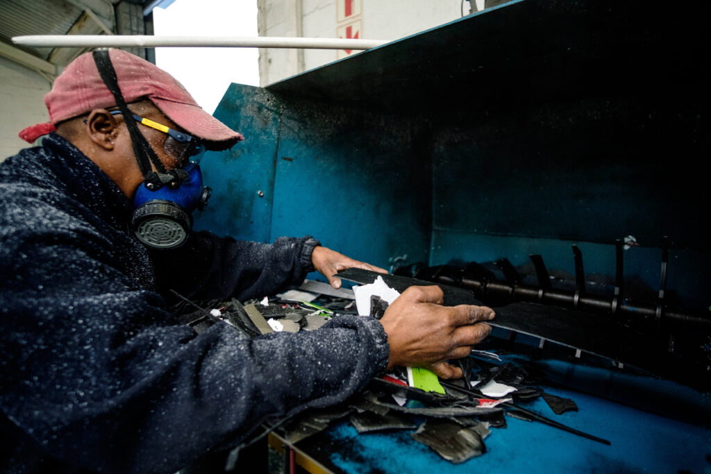 Worker from New Earth Recycling, a Lulalend client in South Africa, operates machinery