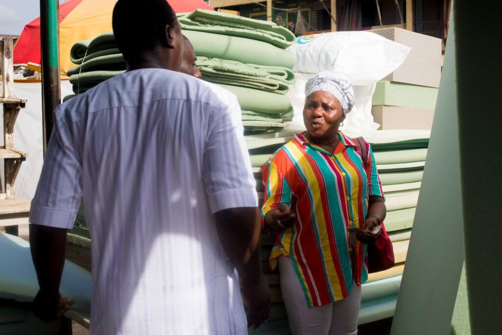 Female entrepreneur Osholabi helps a customer choose a mattress
