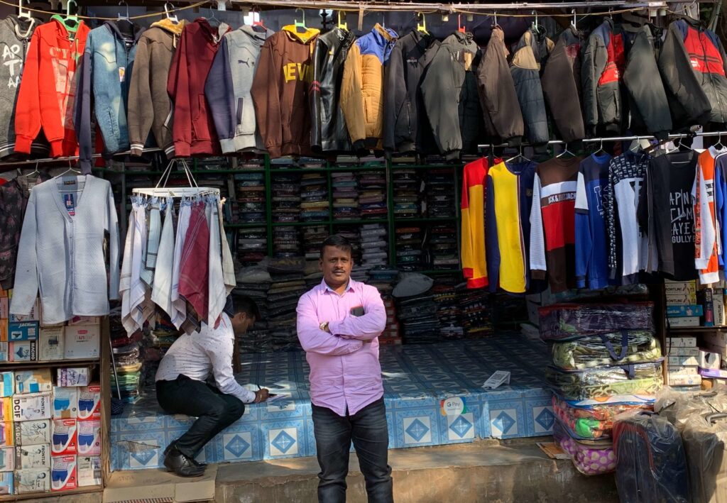 Mohammed Ishaqe stands in front of his storefront in Khurda