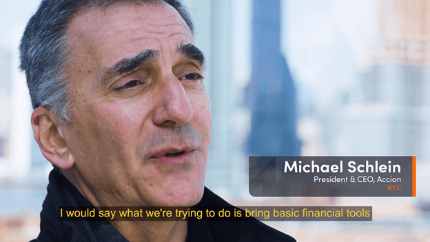 Michael Schlein, President & CEO of Accion, speaks in an interview. Caption reads, "I would say what we're trying to do is bring basic financial tools..." Sentence is cut off.