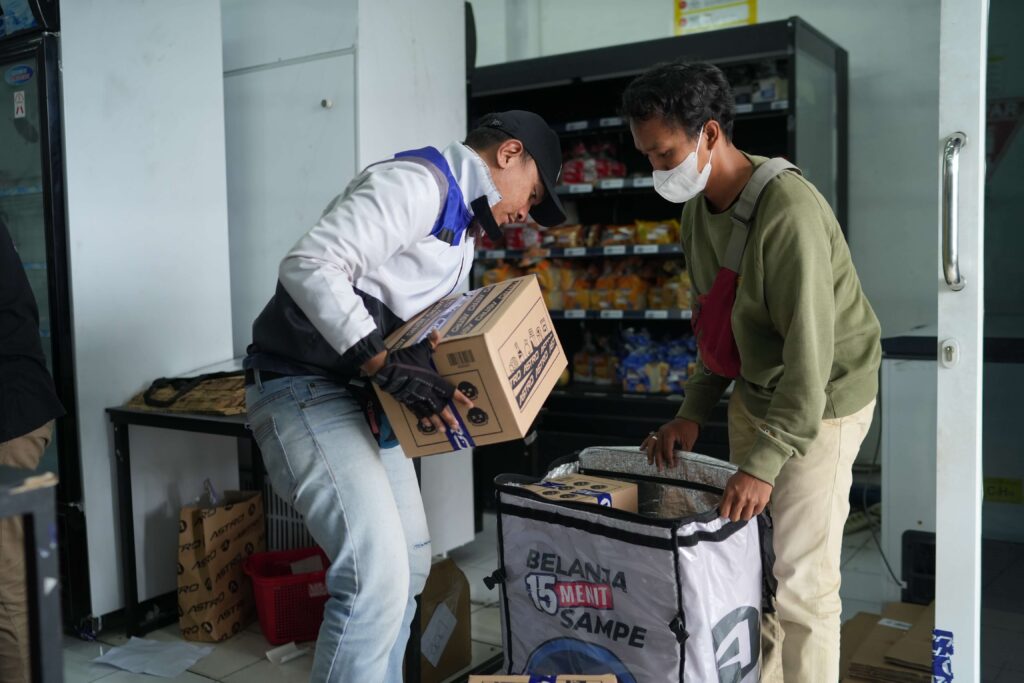 Two gig workers pack a delivery cube