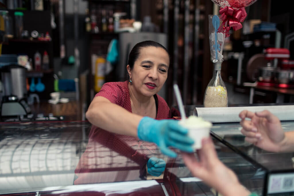 Claudia serves ice cream to a customer in Bogota