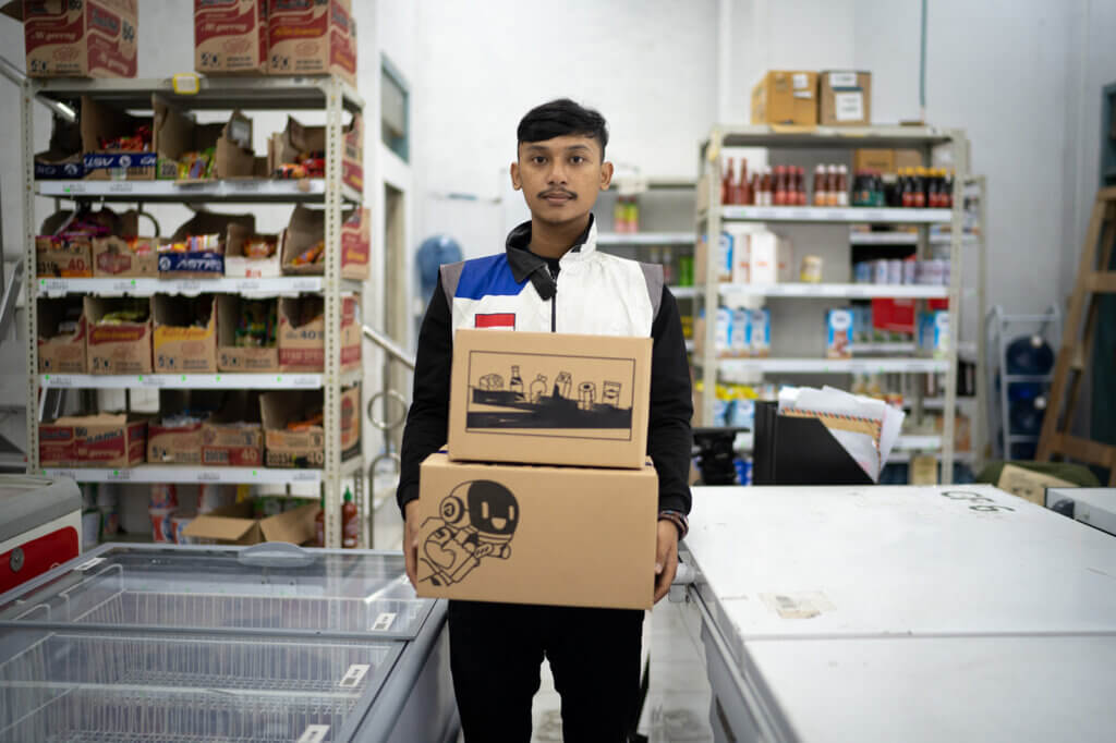 Leonardo carries boxes in a warehouse