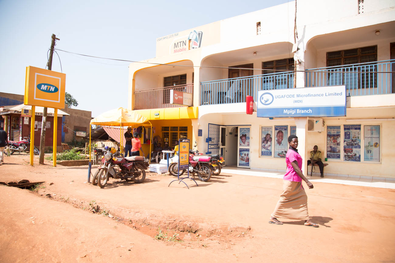 Woman walking in front of a Ugafode location in Uganda