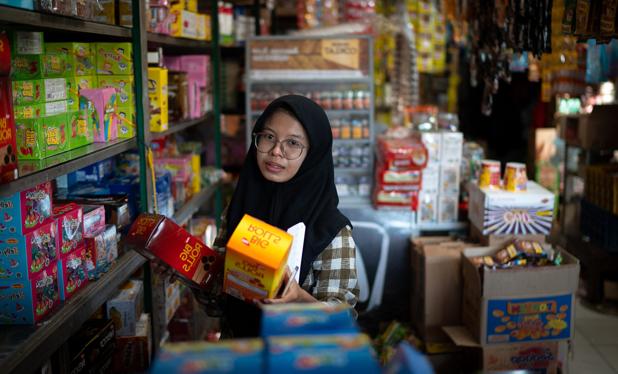 Amelia stocking shelves at her shop in Indonesia