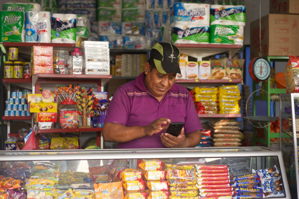 Constantino checks his accounts on his phone in Bolivia