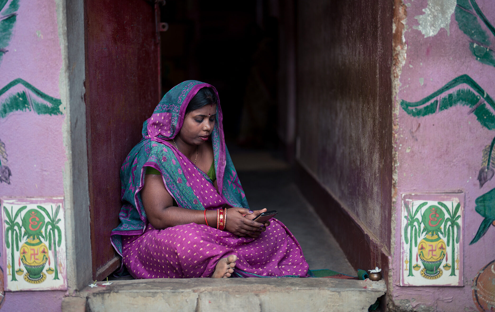 Rina looks at her phone in Odisha, India