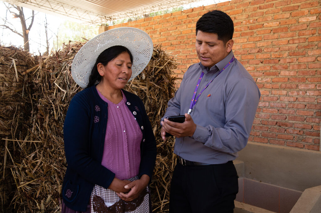 BancoSol advisor shows a customer how to use their banking app