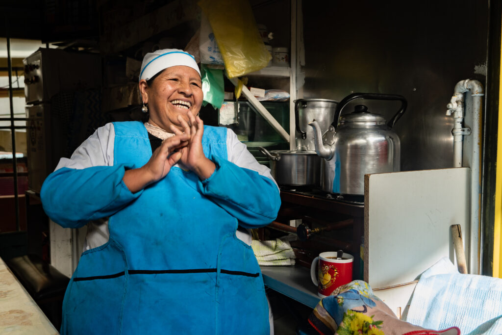 Small business owner sitting and laughing in her kitchen