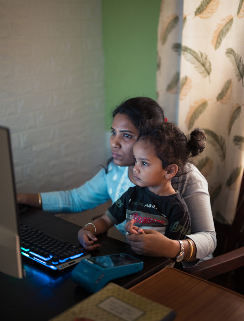 Madhusmita works while her son sits on her lap