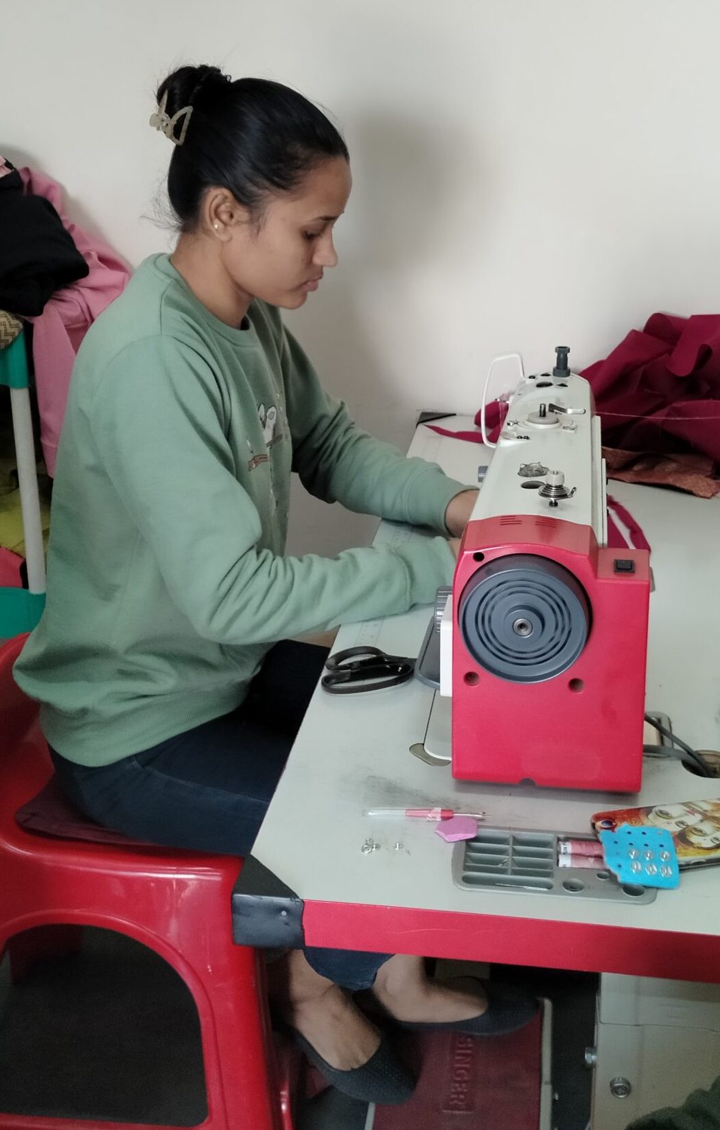 Jyoti sewing using her electric sewing machine